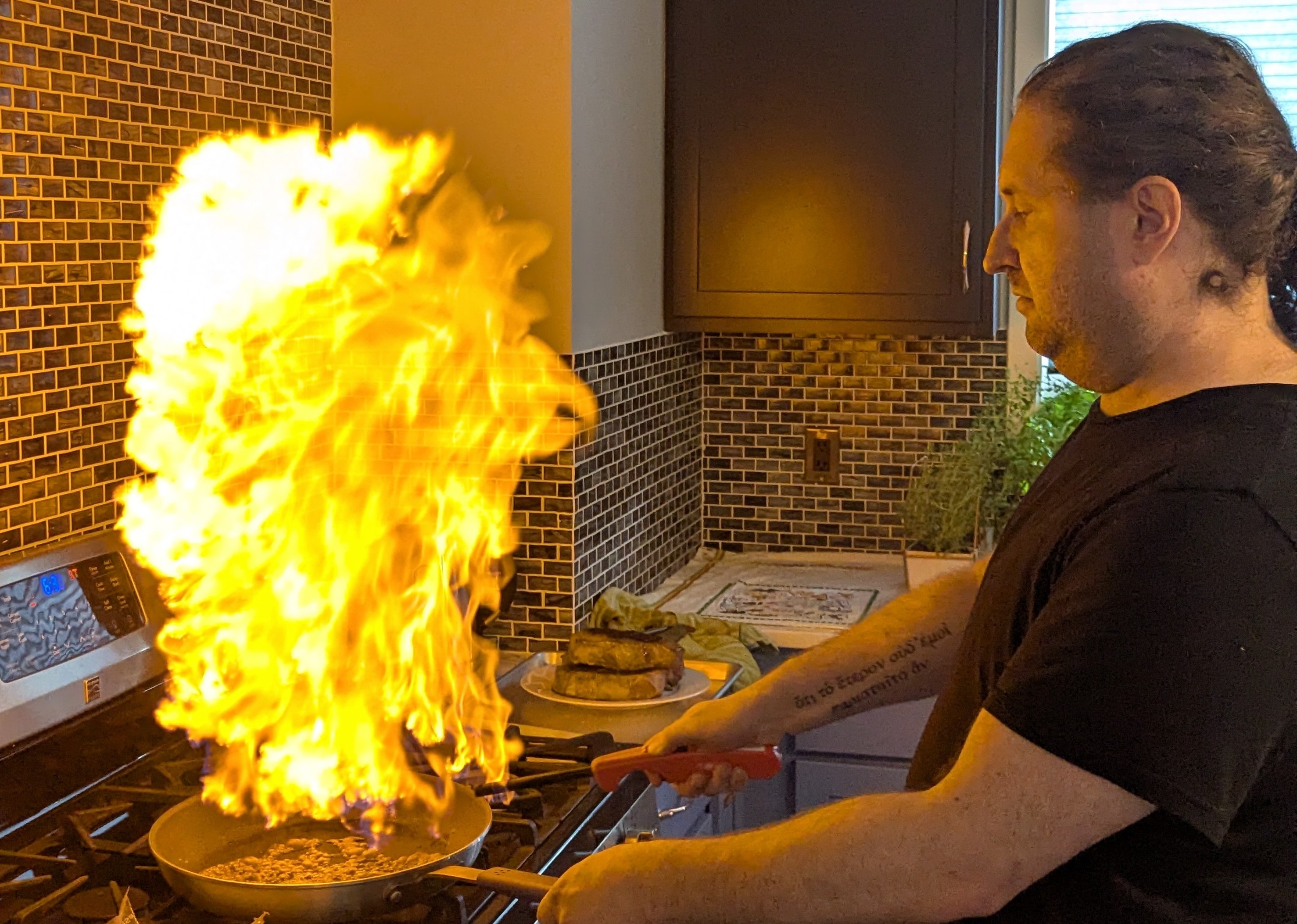 Duane holding a pan with a large flame in it